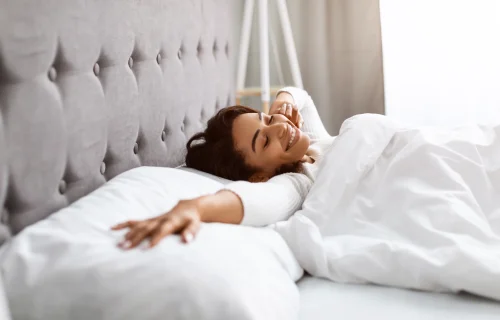 Femme souriante qui se réveille sans douleur dorsale grâce à un matelas adapté à son dos